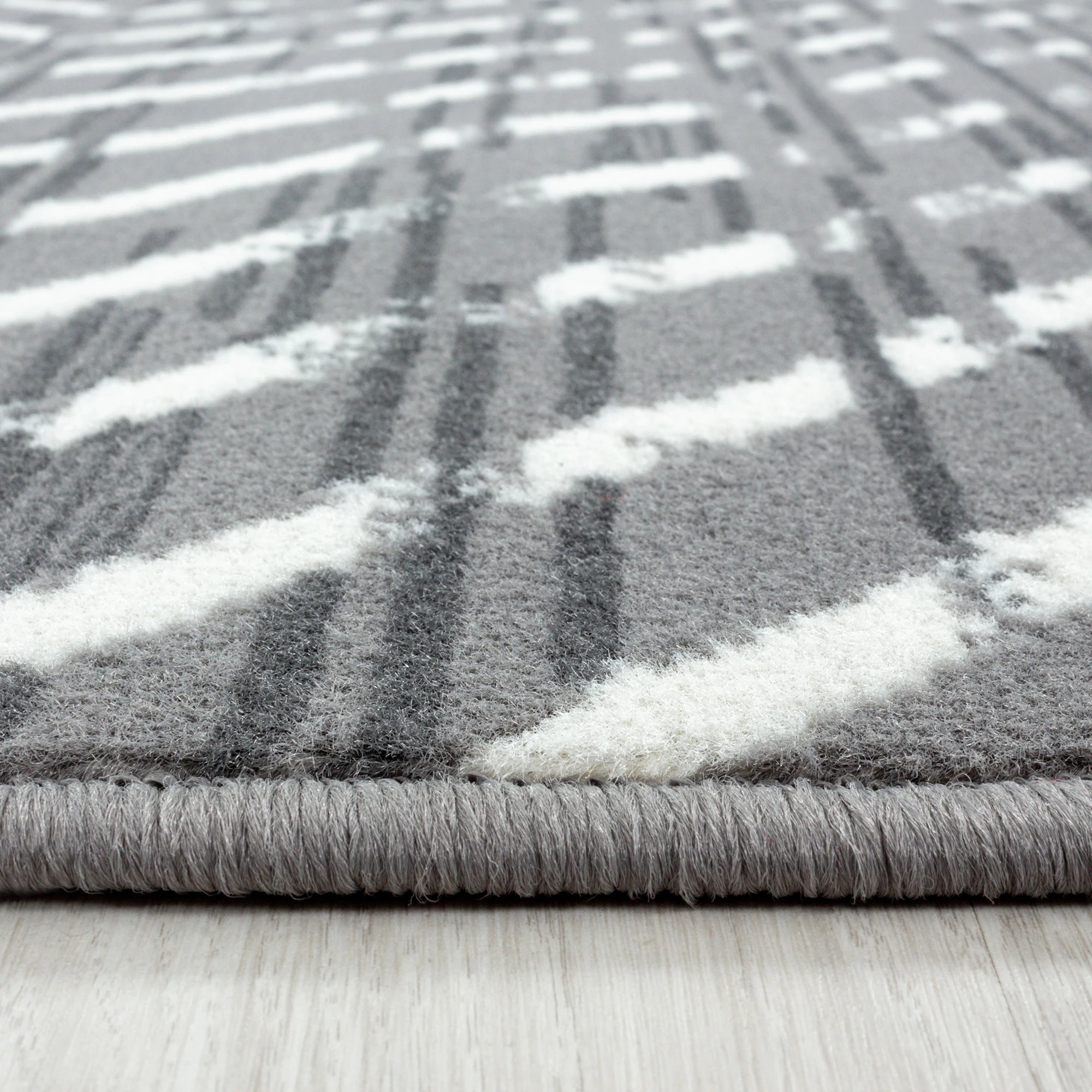 Geometrischer Rautenteppich in Grau
