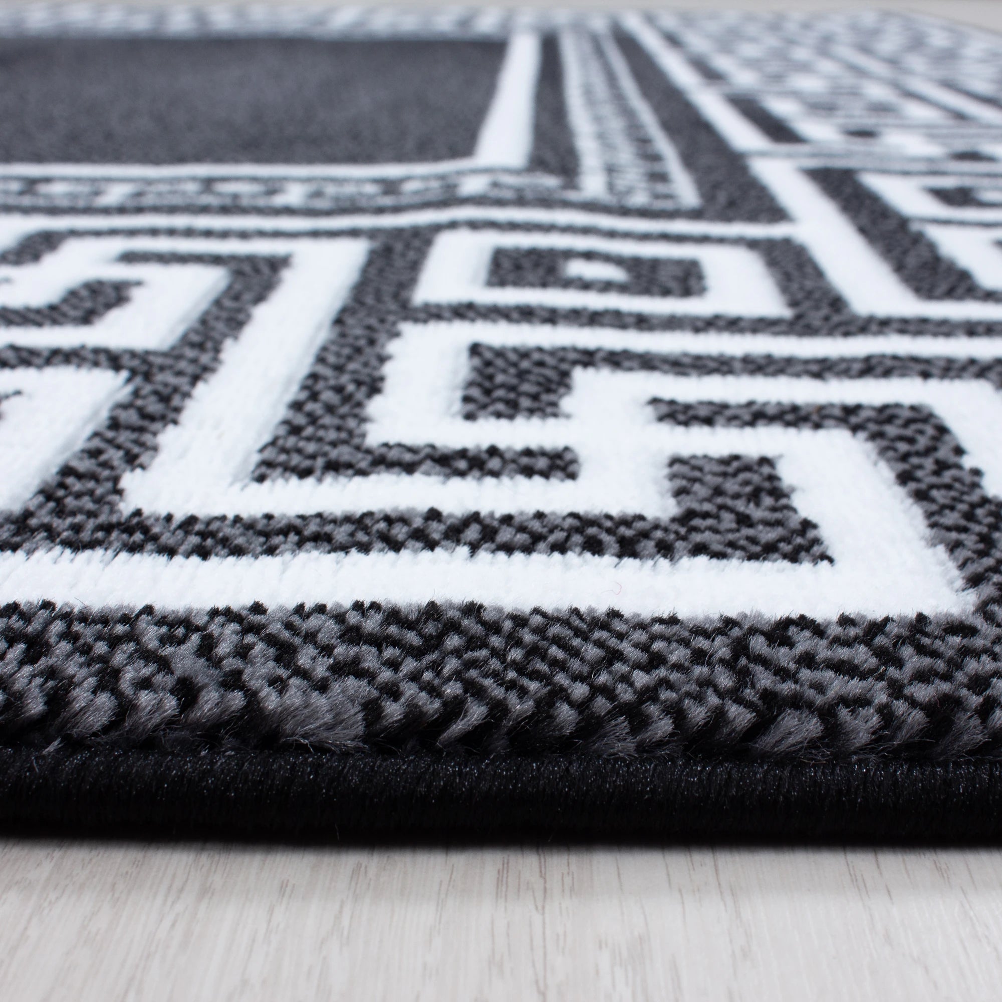 Teppich mit Mäandermuster in Schwarz