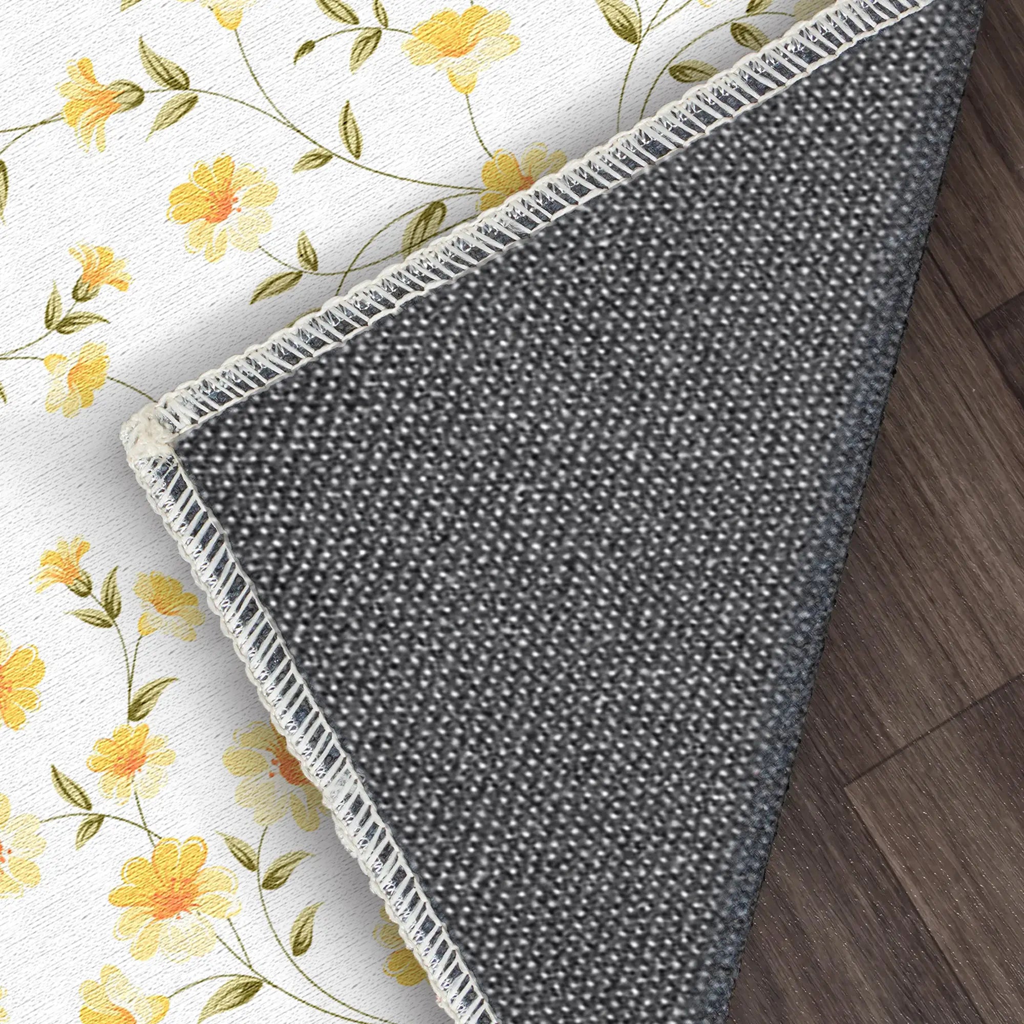 Gray textured rug with white border on a floral-patterned surface
