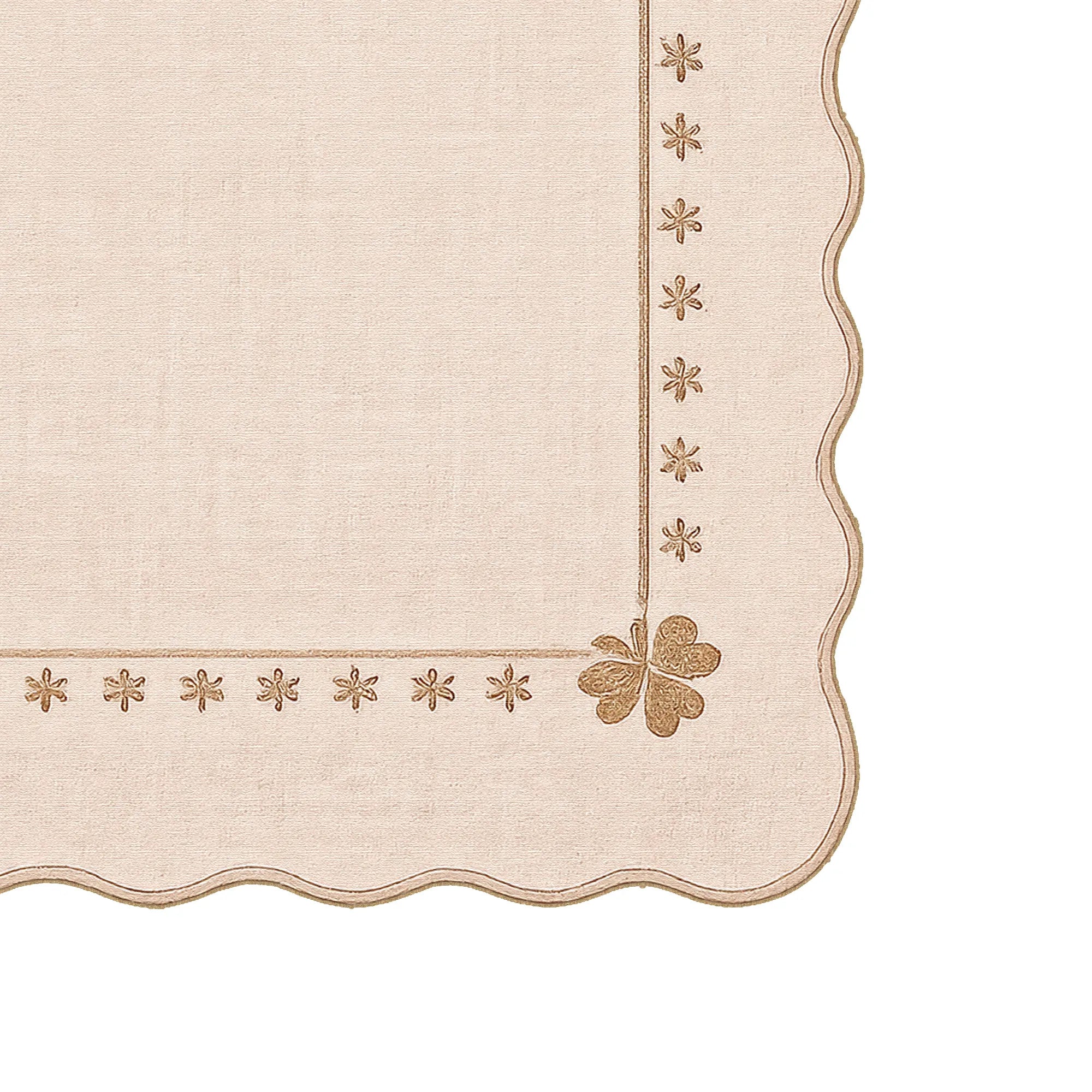 A close-up of a beige linen rug with scalloped edges, featuring embroidered star motifs along the border and a small clover design in the lower right.