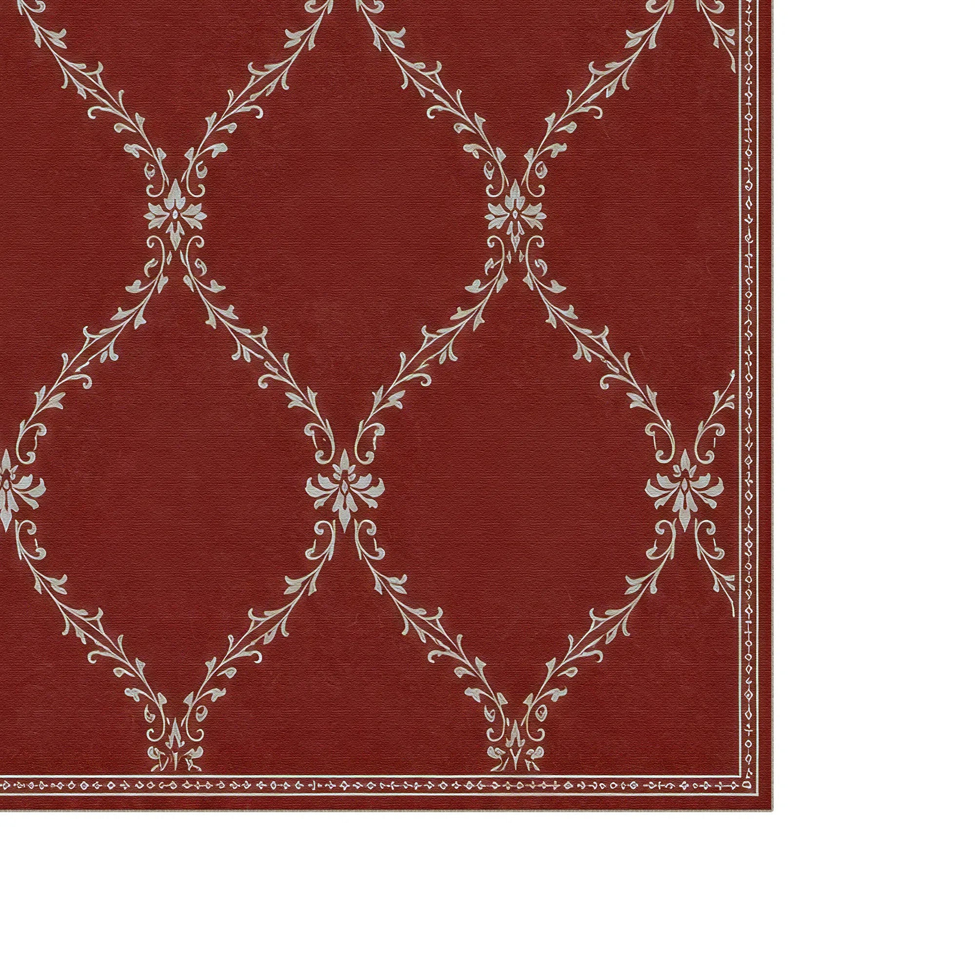 A close-up of a red lattice rug with a white damask-style floral pattern and a decorative border on the right and bottom edges, shown against a white background.
