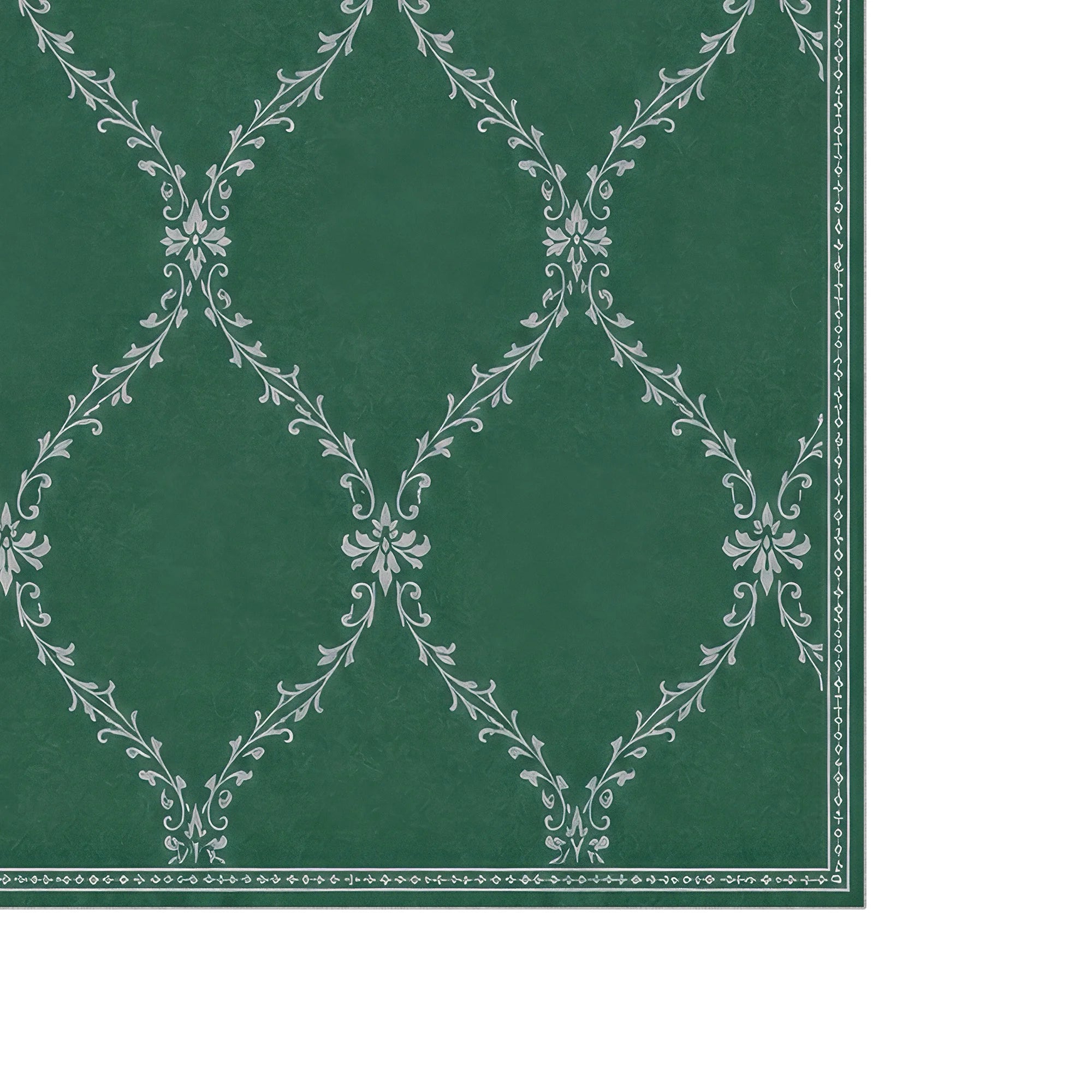 A close-up of a green lattice washable rug with a repeating white damask-style floral pattern and a decorative border along the right edge.
