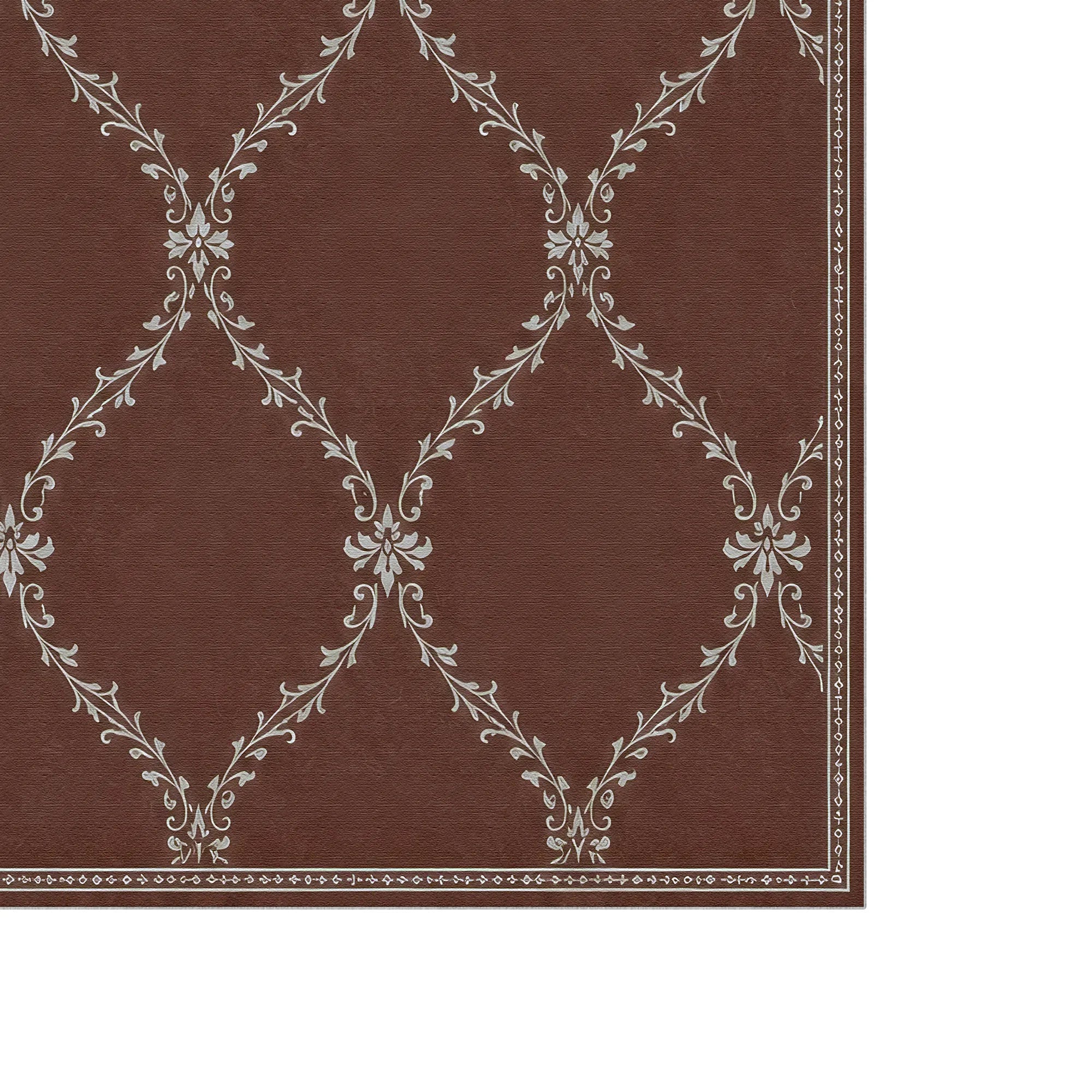 A close-up of a brown lattice rug with a white damask-style floral pattern and a decorative border on the right and bottom edges, shown against a white background.
